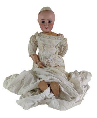 une image représentant une poupée assise sur un drap blanc