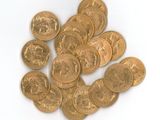 une pile de pièces d'or posée sur une surface blanche