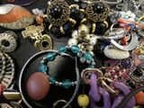 many different types of jewelry on a black table