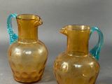 two glass vases sitting next to each other on a table