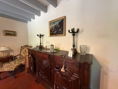 a room with a table, chairs, and a painting on the wall