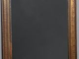 an antique gold framed mirror hanging on a wall next to a wall