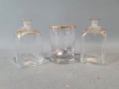 trois bouteilles en verre vides avec des bouchons dorés, posées sur une table