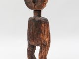 a wooden sculpture of a person with a head on a base
