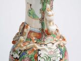 a vase with a bird on it sitting on a table