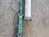 a green hose on the ground next to a yellow and black hose