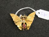 un gros plan d'une broche en forme de papillon sur laquelle est accrochée une étiquette de prix