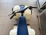 a blue and white moped sitting on a tiled floor