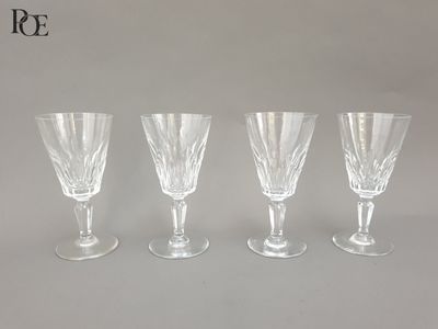 quatre verres à vin transparents posés sur une table blanche