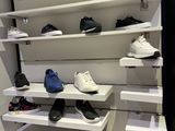 many pairs of shoes on the shelves in the closet