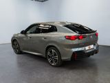 the rear end of a grey bmw suv parked in a showroom