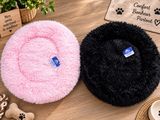 deux paniers pour chiens posés sur une table, avec un os pour chien