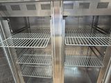 an empty refrigerator with metal shelves inside of it