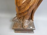 une statue représentant une femme assise sur un bloc de bois