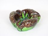 a small green and brown bowl on a white surface