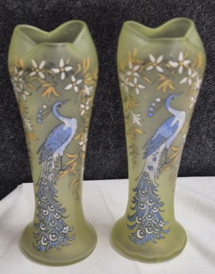 two vases with peacocks painted on them sitting on a table