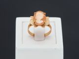 a close up of a gold ring with a face on it
