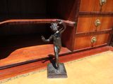 une statue représentant une femme tenant une balle, posée sur un bureau