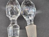 pair of clear glass salt and pepper shakers on a black surface