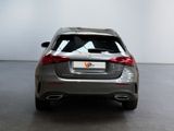 the rear end of a silver car in a room with a white wall