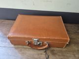 a brown suitcase sitting on a wooden floor