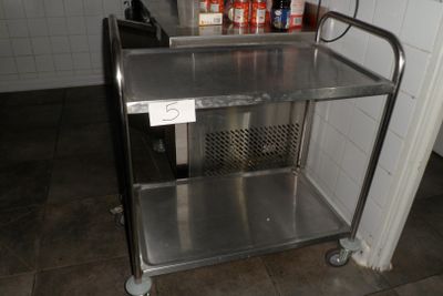 un chariot en acier inoxydable sur lequel sont posées des bouteilles, dans une cuisine