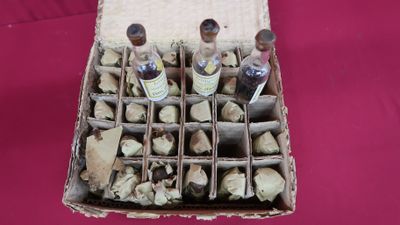 a box full of wine bottles and corks on a table