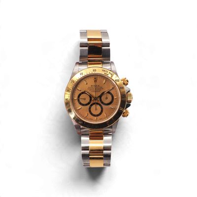 une image représentant une montre en or et en argent posée sur une surface blanche