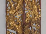 deux décorations représentant des dragons dorés accrochées l'une à côté de l'autre au mur