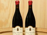 deux bouteilles de vin posées sur un tonneau en bois