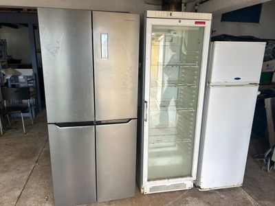 deux réfrigérateurs et un congélateur dans un garage