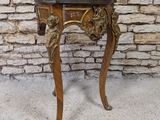 a small wooden table with a marble top on a stone floor