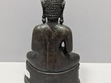 statue of a person sitting in a meditation position on a white surface