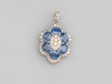 an 18k white gold diamond and blue sapphire pendant