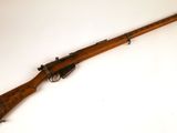 un vieux fusil avec un canon en bois et une poignée en bois