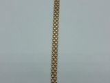 a close up of a gold bracelet on a white surface