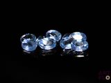 a pair of blue topazte gems on a black surface