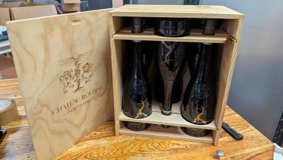 des bouteilles de vin dans une caisse en bois posée sur une table en bois