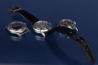 deux montres sont posées l'une à côté de l'autre sur une surface bleue