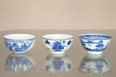 three blue and white bowls sitting on top of a table next to each other