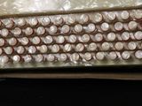 a lot of white and red buttons in a plastic bag