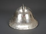 a silver metal helmet with a red handle on a gray surface
