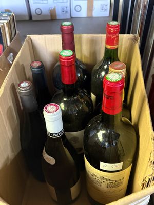 plusieurs bouteilles de vin dans un panier posé sur le comptoir