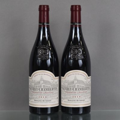 two bottles of red wine sitting on top of a glass table