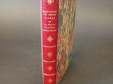 a red book with gold trim sitting on a table