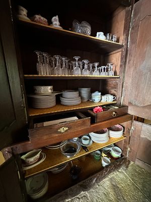 many dishes and glasses on the shelves in this old kitchen