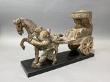 statue of a horse pulling a carriage with a man on it
