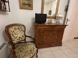 a chair and a dresser in a room with a mirror on the wall
