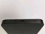 the back of a black cell phone sitting on top of a white table