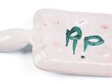 a small white plate with a green bird design on it